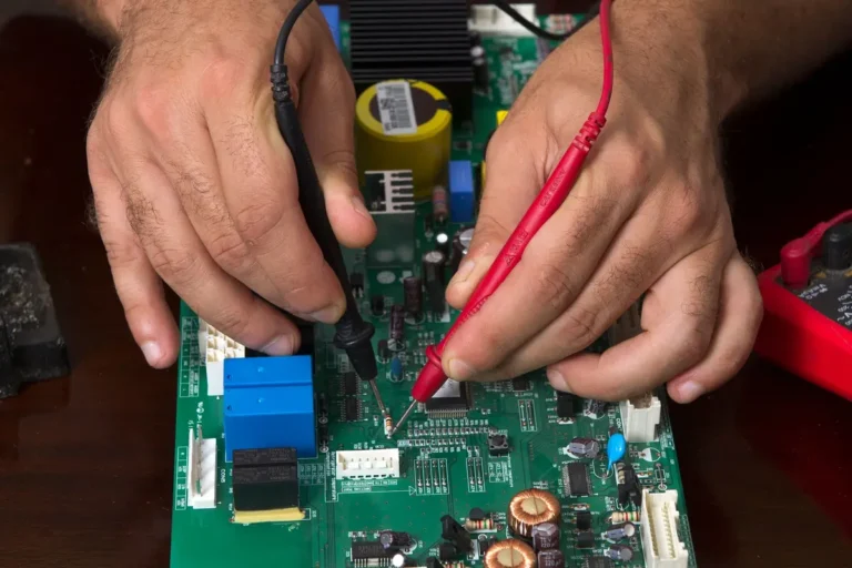 Diagnóstico técnico: manos midiendo con un multímetro la placa electrónica de un electrodoméstico