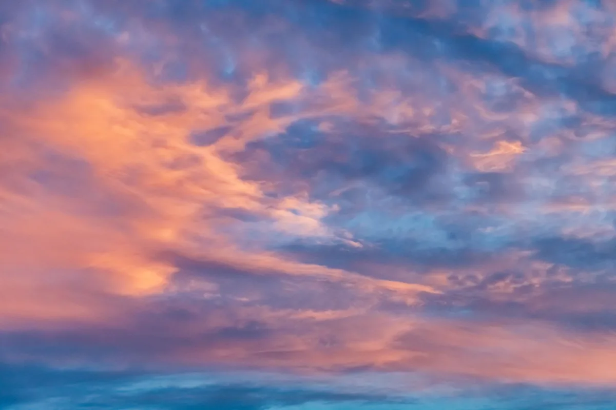 Nubes teñidas de naranja y rosa por el atardecer sobre un horizonte despejado